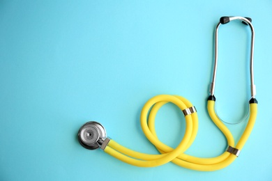 Photo of New stethoscope on color background, top view