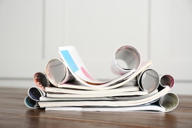 Photo of Many open stacked magazines on wooden table