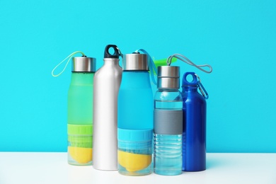 Photo of Different water bottles for sports on color background