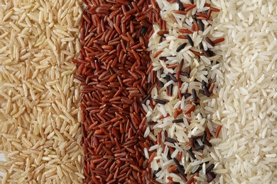 Photo of Brown and other types of rice as background, closeup