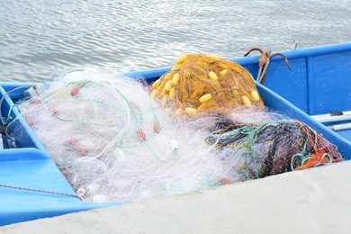 Photo of Many stacked fishing nets in boat near sea