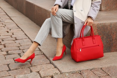 Photo of Stylish woman with trendy leather bag on city street, closeup