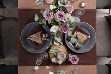 Photo of Elegant table setting with beautiful floral decor and burning candles, top view