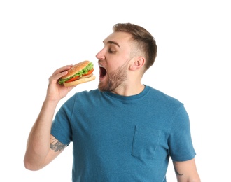 Photo of Young man eating tasty burger on white background