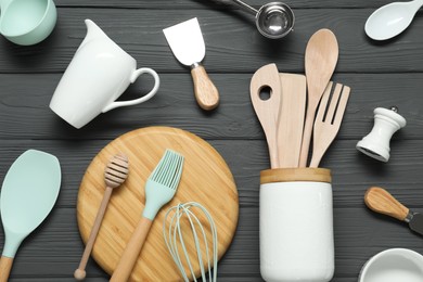 Photo of Set of different kitchen utensils on grey wooden table, flat lay
