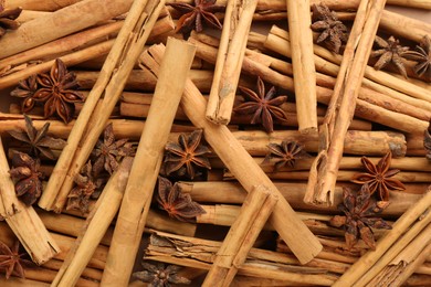 Photo of Aromatic cinnamon sticks and anise as background, top view