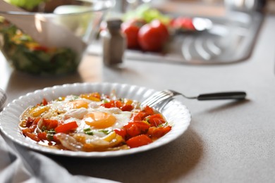 Photo of Plate of tasty fried eggs with vegetables on table in kitchen. Space for text