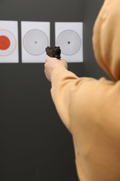 Photo of Man aiming at shooting target indoors, closeup