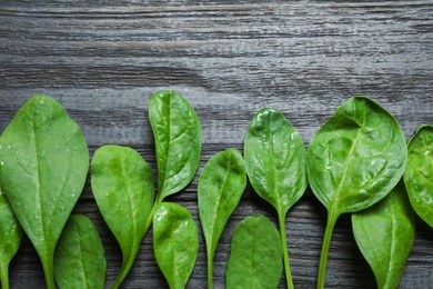 Fresh green healthy spinach on dark wooden table, flat lay