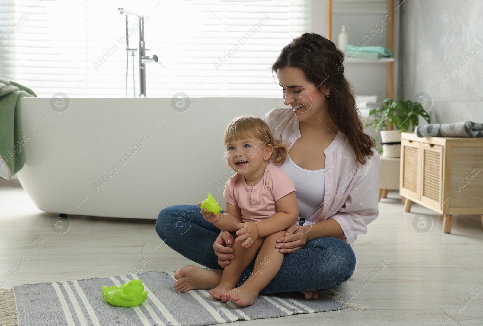 Photo of Mother playing with her daughter in bathroom