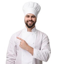 Happy young chef in uniform pointing at something on white background