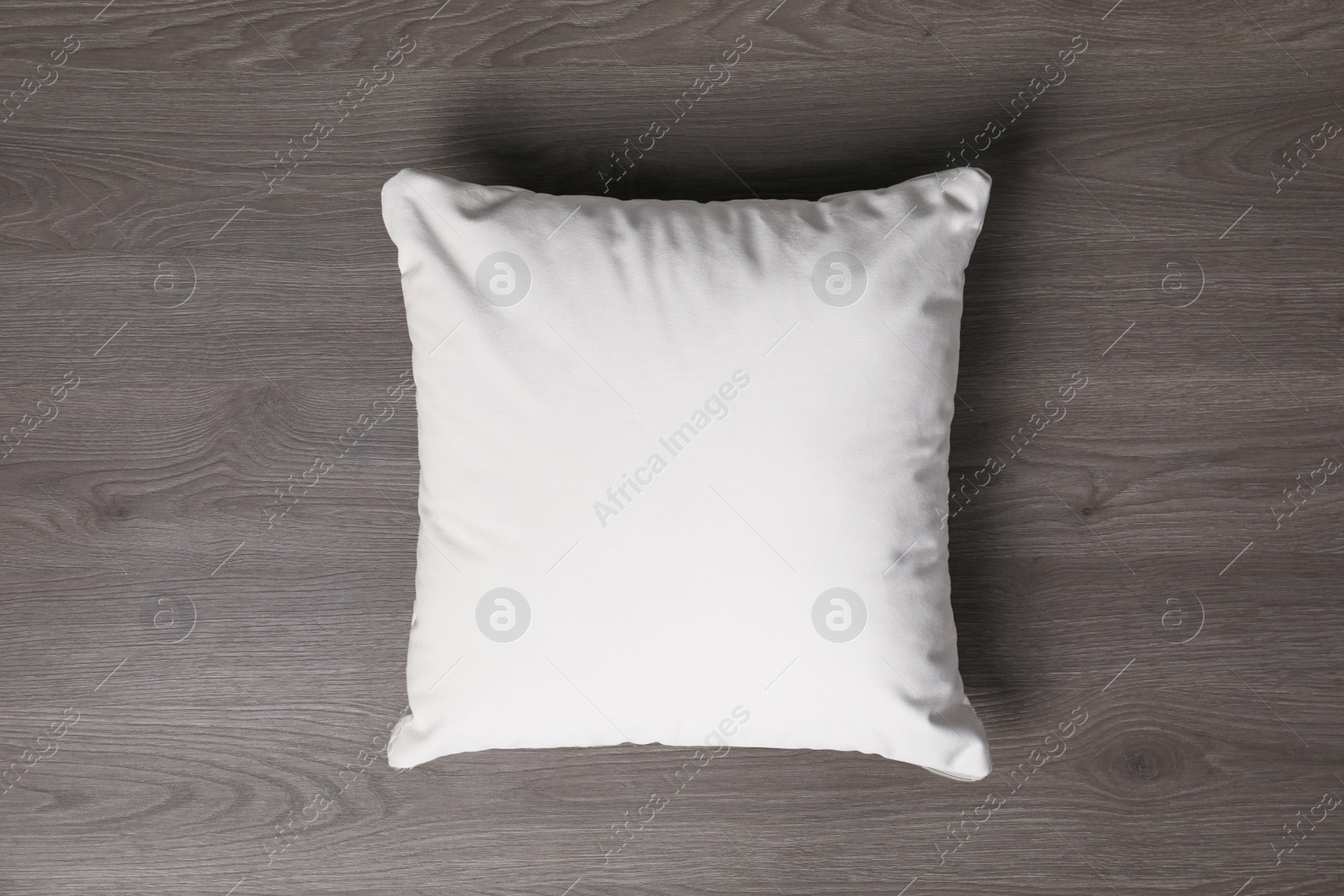 Photo of Blank soft pillow on wooden background, top view