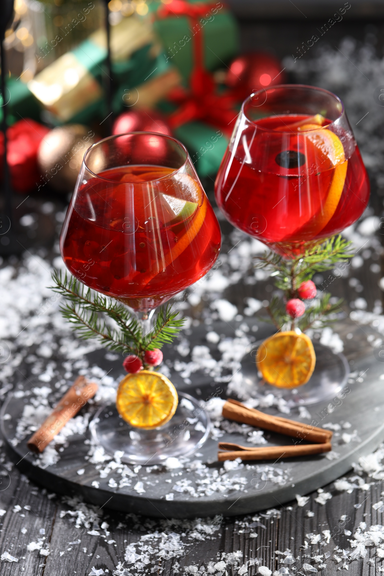 Photo of Christmas Sangria cocktail in glasses and snow on dark wooden table