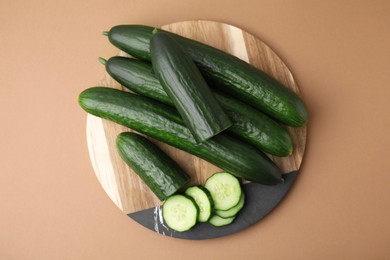 Fresh cucumbers on beige background, top view