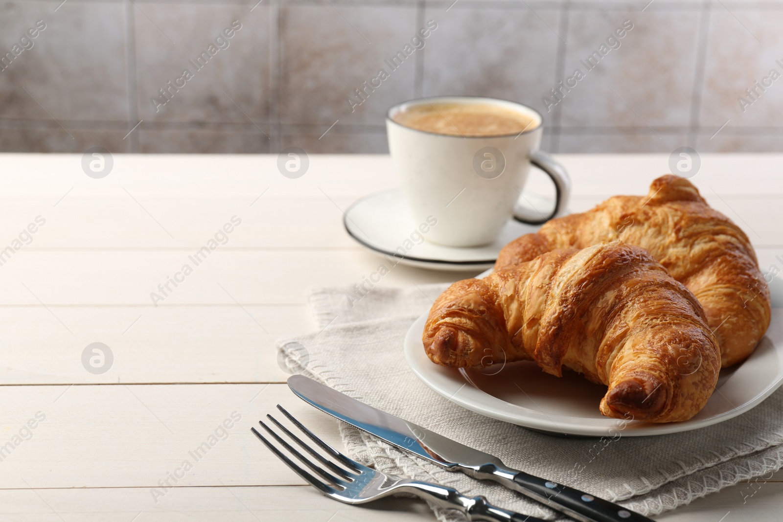 Photo of Delicious fresh croissants served with coffee on white wooden table, space for text