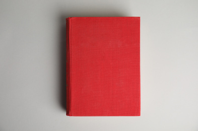 Hardcover book on light grey background, top view. Space for design