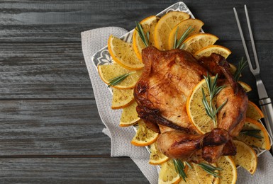 Photo of Baked chicken with orange slices on grey wooden table, flat lay. Space for text