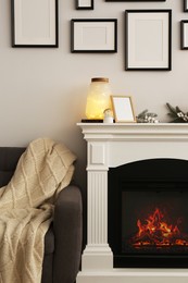 Stylish interior decorations on fireplace near white wall indoors