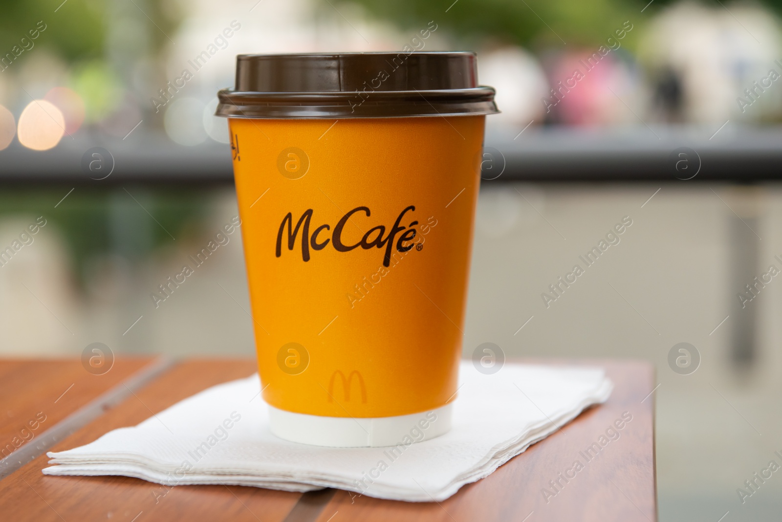 Photo of WARSAW, POLAND - SEPTEMBER 04, 2022: McDonald's hot drink on wooden table outdoors, space for text