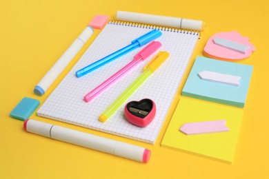 Photo of Different school stationery on yellow background. Back to school
