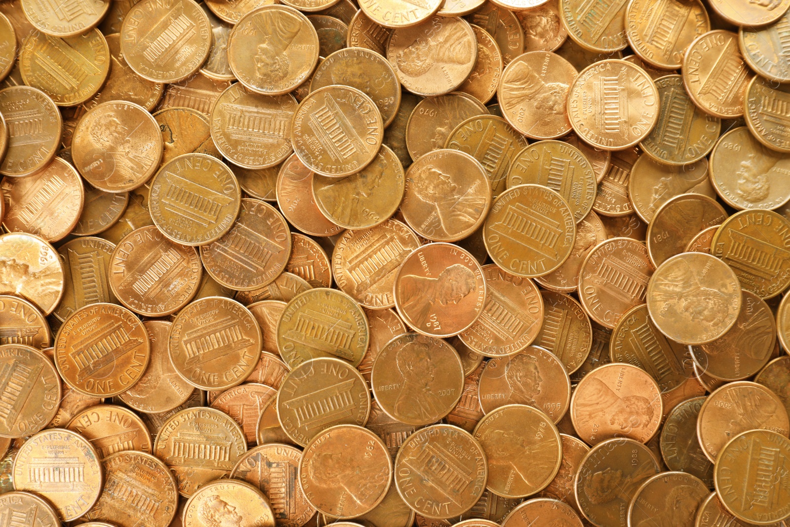 Photo of Pile of shiny USA one cent coins as background, top view