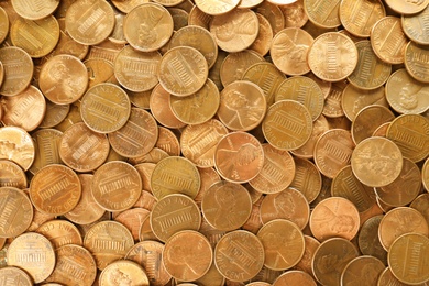 Pile of shiny USA one cent coins as background, top view