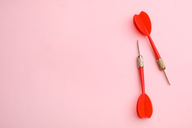 Red dart arrows on pink background, flat lay with space for text