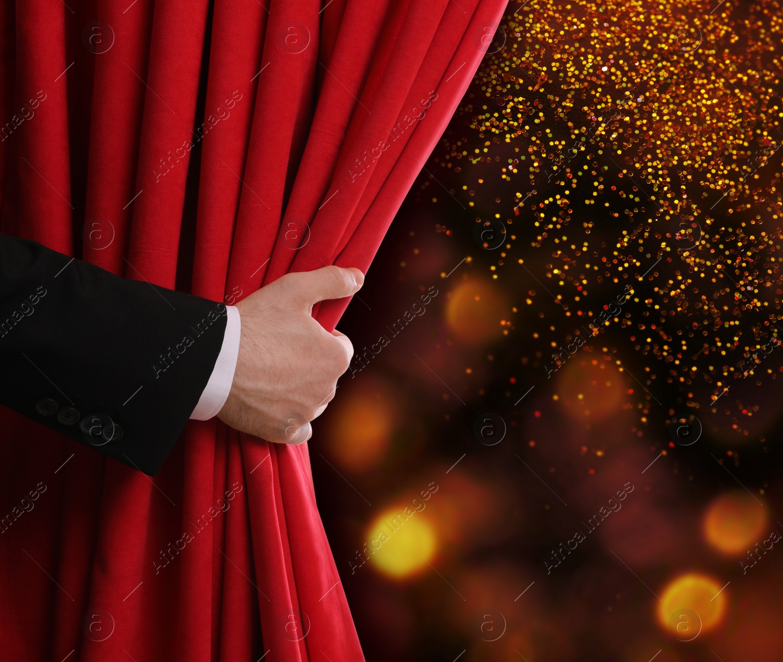 Image of Man opening red front curtain against blurred lights. Bokeh effect 