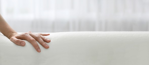 Image of Woman touching memory foam pillow indoors, closeup. Banner design with space for text
