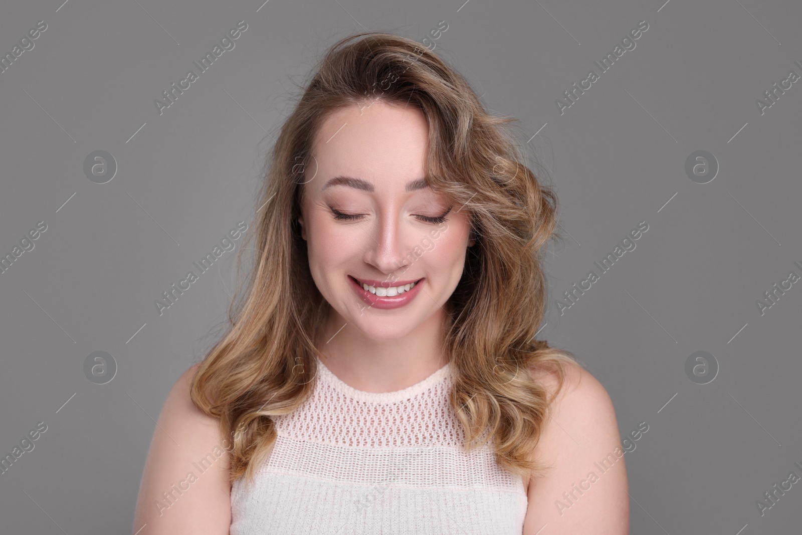 Photo of Portrait of smiling woman on grey background
