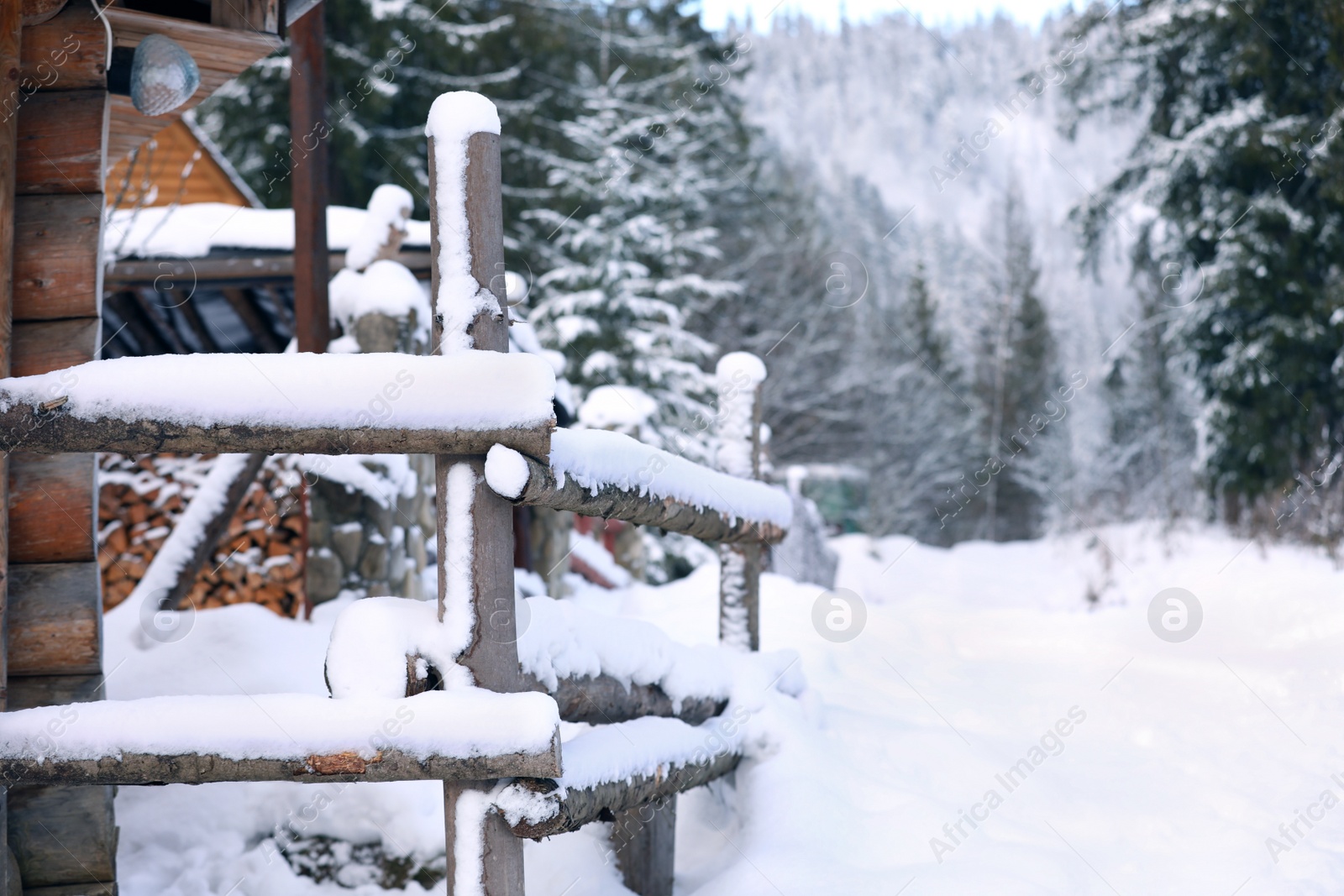 Photo of Wooden fence covered with snow outdoors on winter day