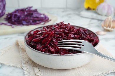 Photo of Tasty red cabbage sauerkraut on white marble table, closeup