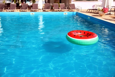 Inflatable ring floating in swimming pool on sunny day