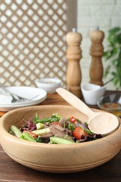 Photo of Delicious salad with beef tongue, vegetables and spoon served on wooden table