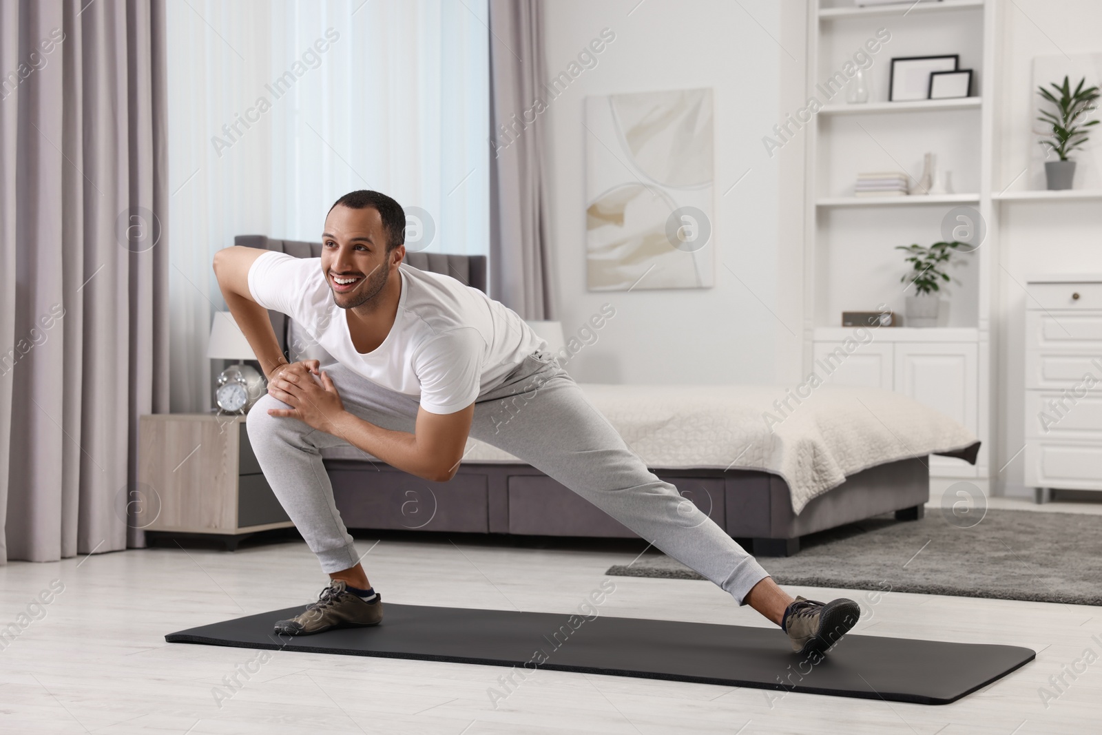 Photo of Man doing morning exercise on fitness mat at home