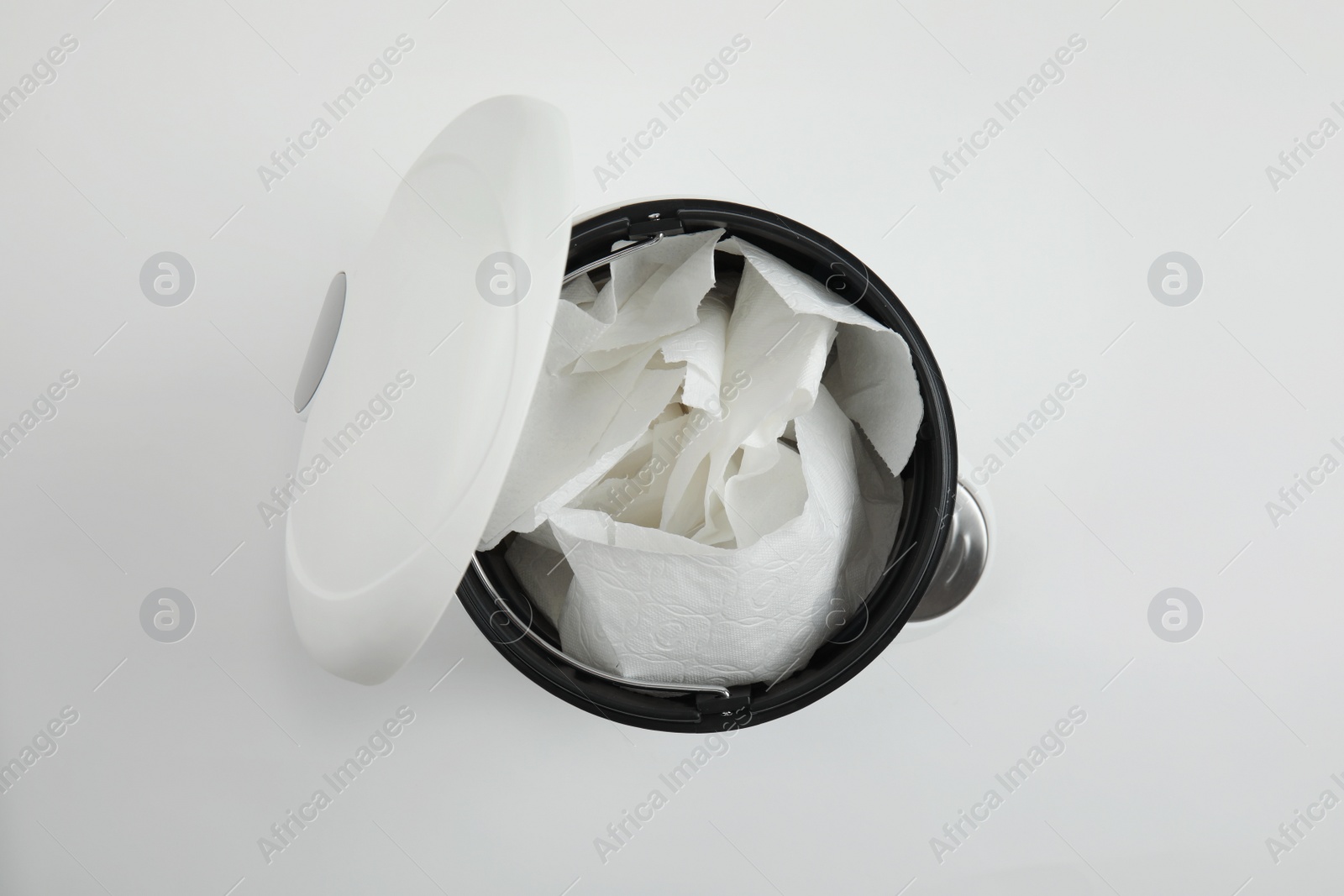 Photo of Trash bin with used toilet paper on white background, top view