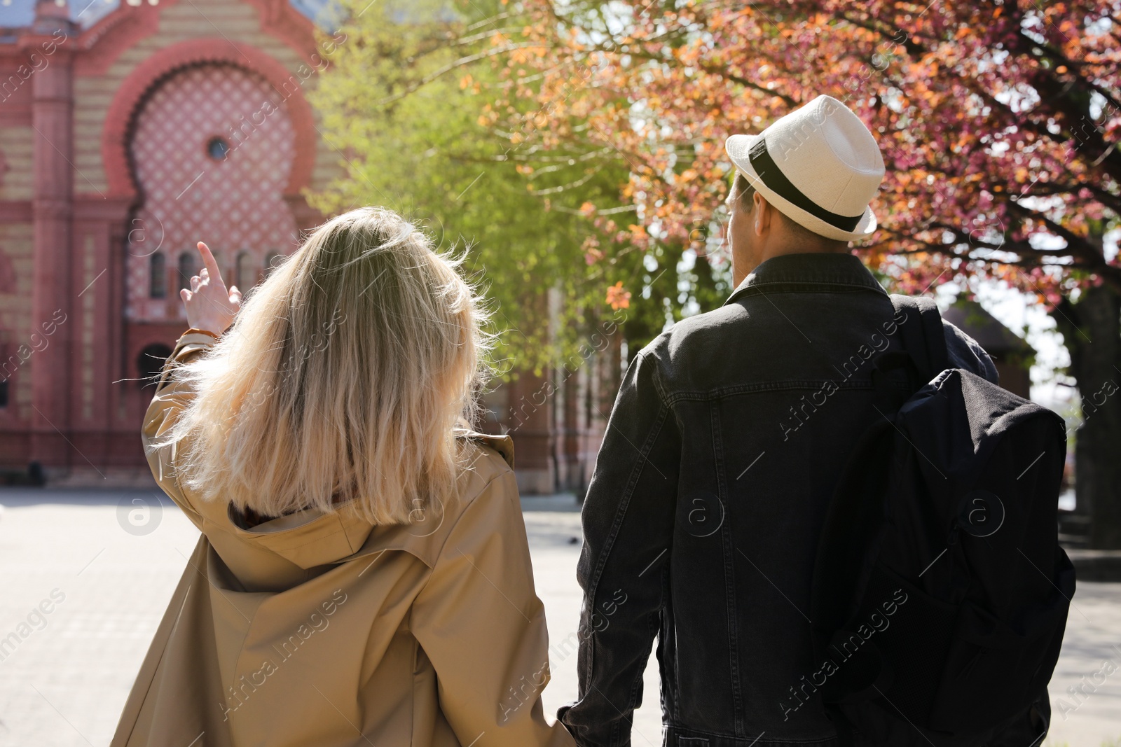 Photo of Couple of tourists walking on city street