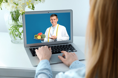 Image of Woman using laptop for online consultation with nutritionist via video chat, closeup