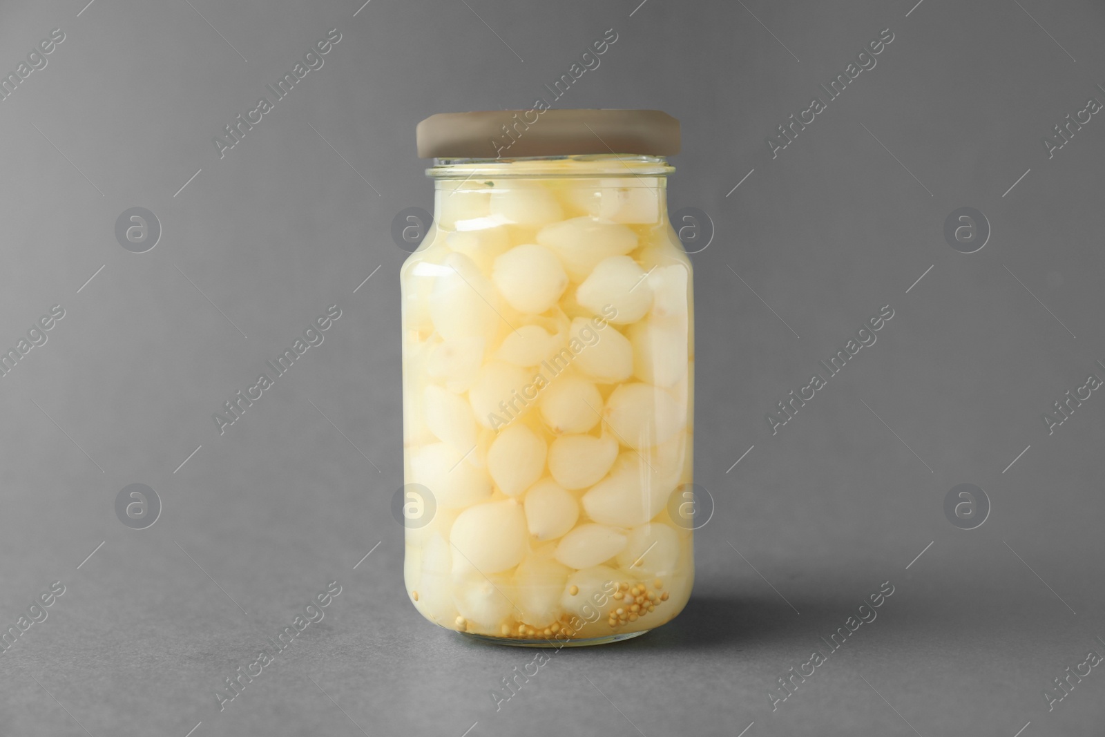 Photo of Jar of pickled onions on grey background