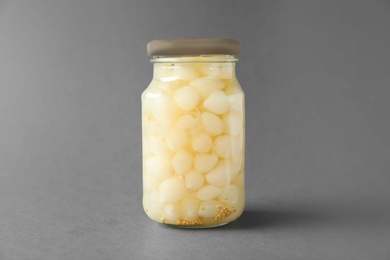 Jar of pickled onions on grey background