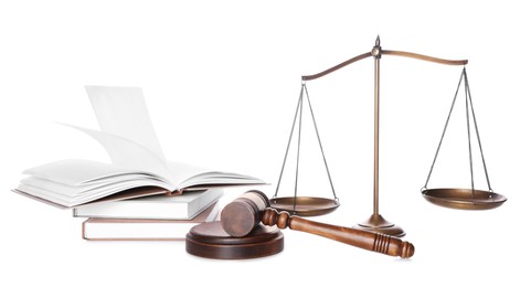 Photo of Wooden gavel, books and scales of justice on white background