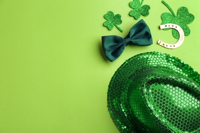 Photo of Leprechaun's hat and St. Patrick's day decor on green background, flat lay. Space for text