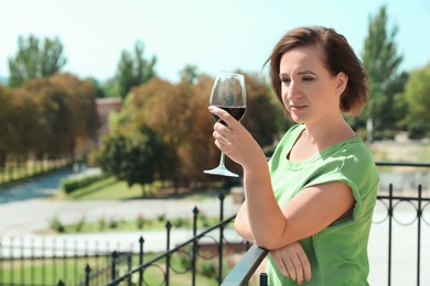 Photo of Woman with glass of red wine outdoors