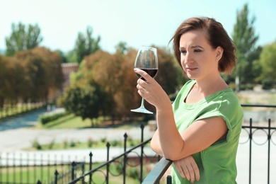 Woman with glass of red wine outdoors