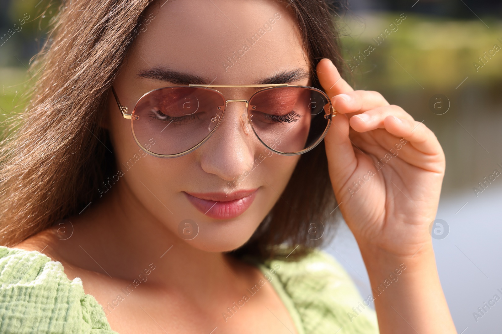 Photo of Beautiful woman in sunglasses outdoors on sunny day, closeup