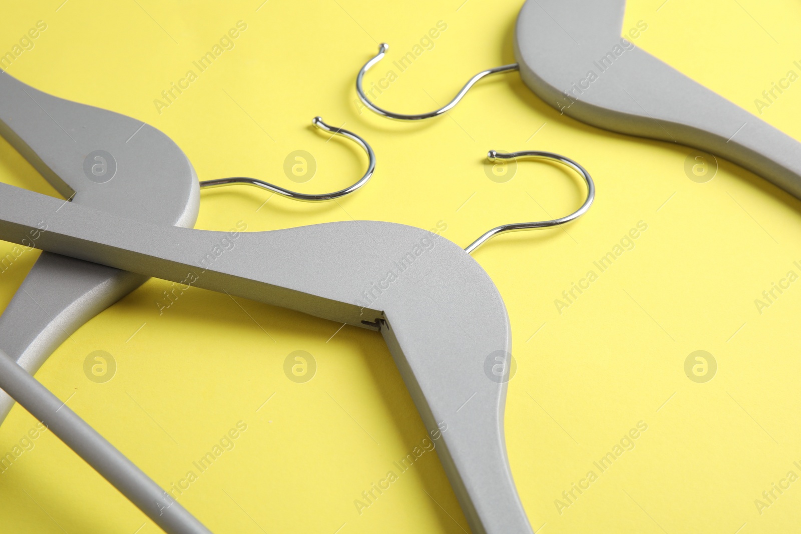 Photo of Empty wooden hangers on color background, view from above