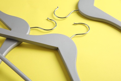 Photo of Empty wooden hangers on color background, view from above