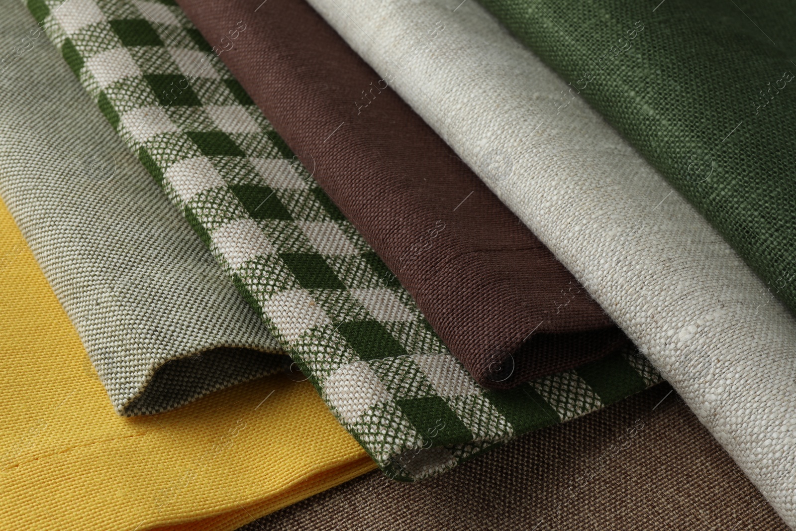 Photo of Many different fabrics on brown cloth, closeup