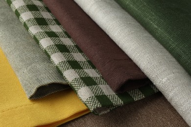 Photo of Many different fabrics on brown cloth, closeup