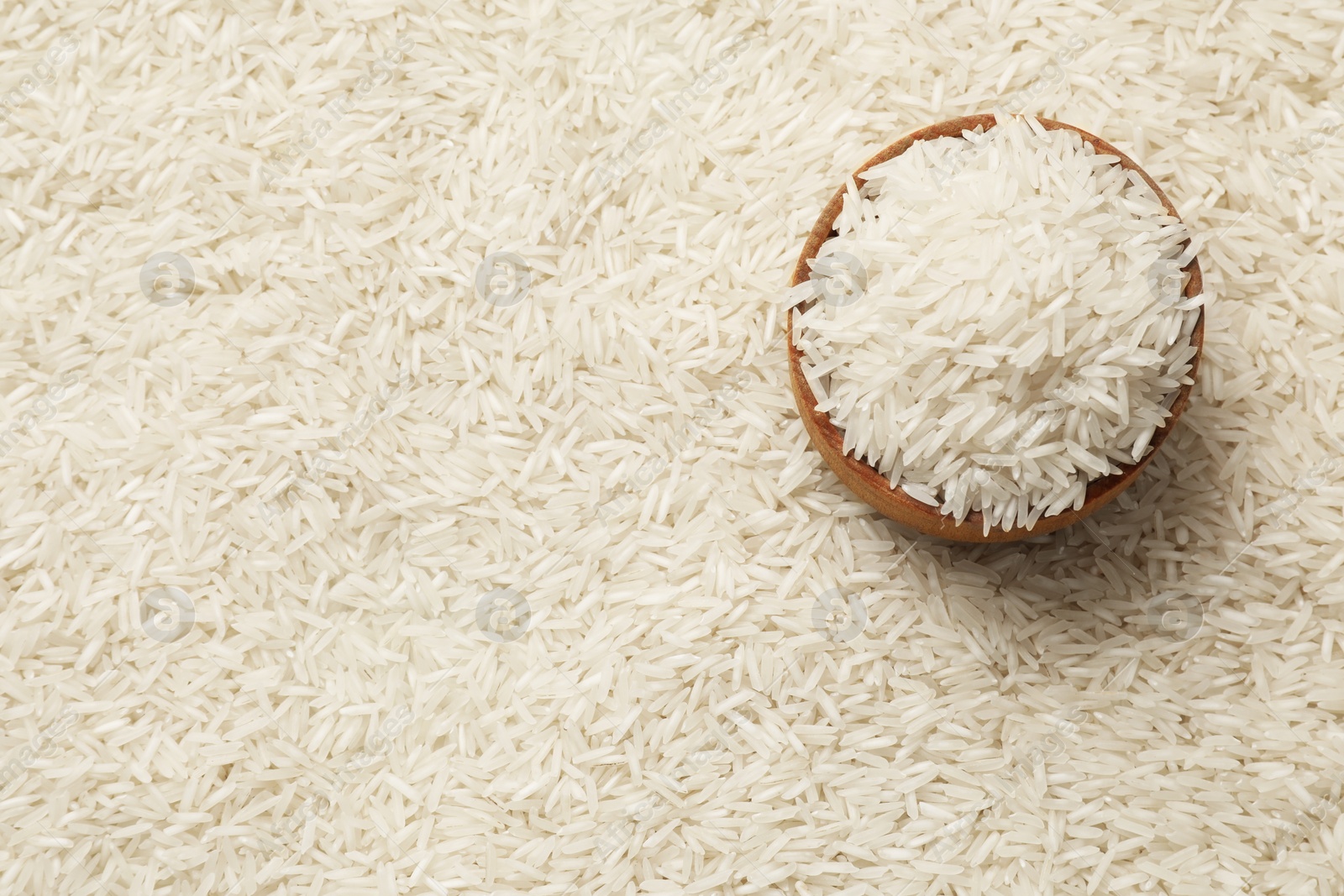 Photo of Raw basmati rice and bowl, top view. Space for text